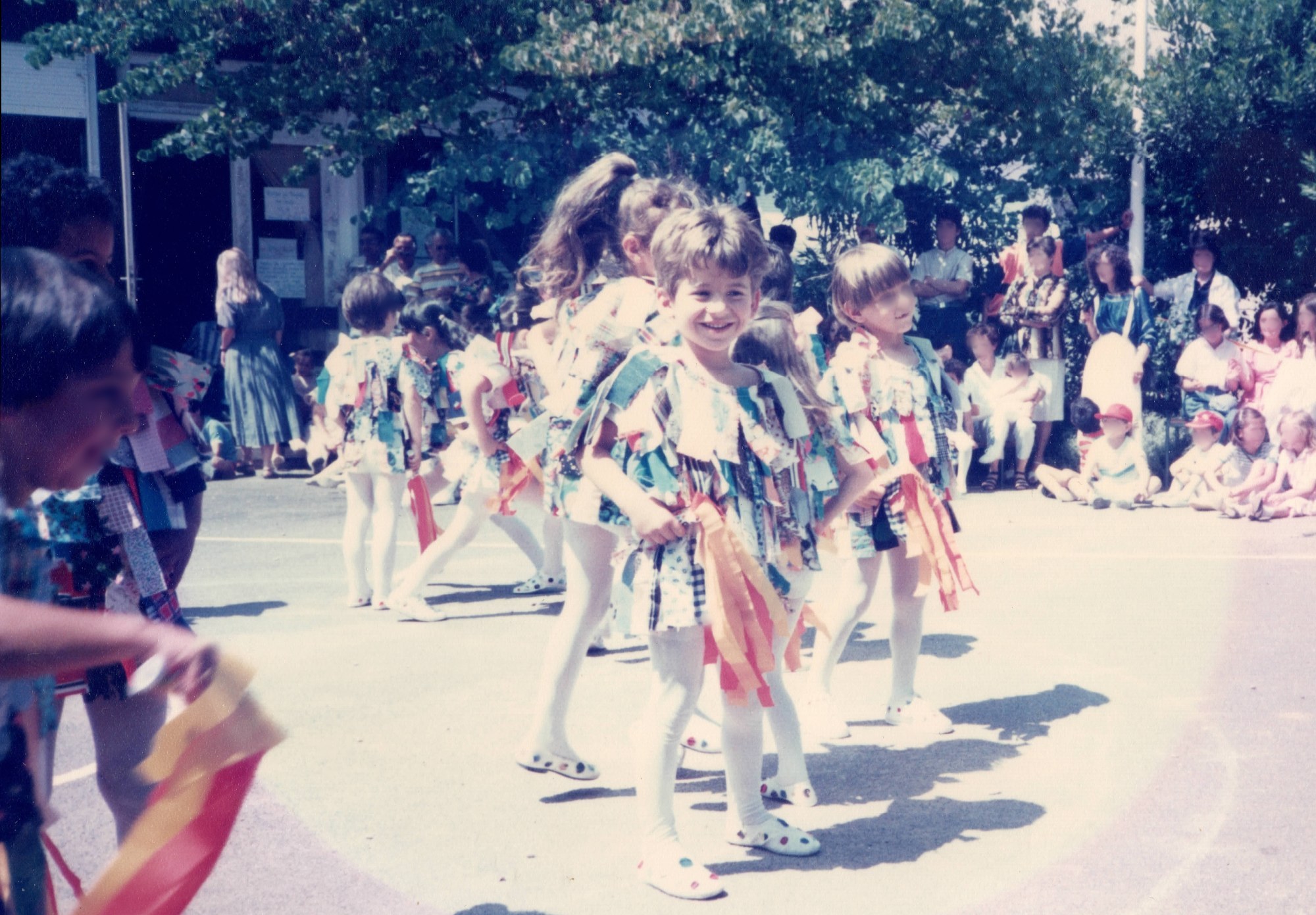Votre artisan encore enfant — photo de kermesse avant restauration patrimoniale, école maternelle Les Oliviers, Béziers, printemps 1985 — atelier Grain & Pixel